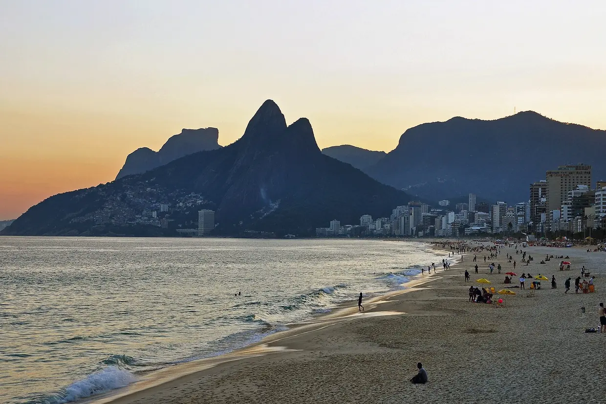 Atardecer en la playa de Ipanema, con la silueta del morro Dois Irmãos y los edificios del barrio
